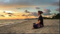 Woman relaxing on beach at sunset