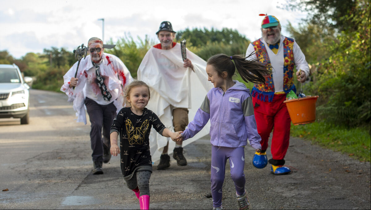 Ava and Ellie Sweeney running for their lives from Cork's oldest trick-or-treaters John A. Murphy, Martin Murphy and Con Prout who have been trick-or-treating together for decades in Crossbarry, Co Cork. Picture Dan Linehan Ava and Ellie Sweeney running for their lives from Cork's oldest trick-or-treaters John A. Murphy, Martin Murphy and Con Prout who have been trick-or-treating together for decades in Crossbarry, Co Cork. Picture Dan Linehan