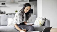 Woman analyzing documents while sitting at home