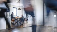 Businesspeople in Conference Room and Colleagues Walking By