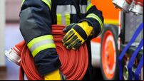 Firefighter wearing a rolled hose