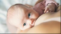 Baby eating mother's milk. Mother breastfeeding baby.