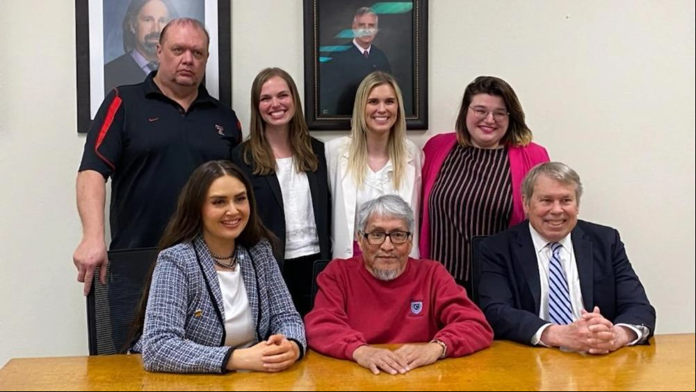 James Reyos, seated front center, next to Allison Clayton, left side, along with the other  of the Innocence Project of Texas team that got him exonerated for the murder of Father Patrick Ryan in Odessa in 1981.