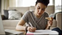 Female student studying and listening to music at home