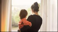 Mother and son looking out of window