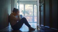 Sad Young Woman Sitting on the Floor In the Hallway of Her Appartment, Covering Face with Hands. Atmosphere of Depression, Troub
