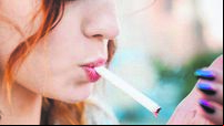 Close-Up Of Woman Burning Cigarette