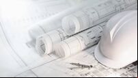 Hard hat and com on architectural blueprints and construction technology and future industry