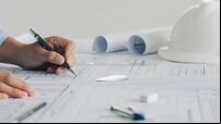 Close-up Of Engineer Hand Drawing Plan On Blue Print with architect equipment,architectural plan, sketching a construction proje