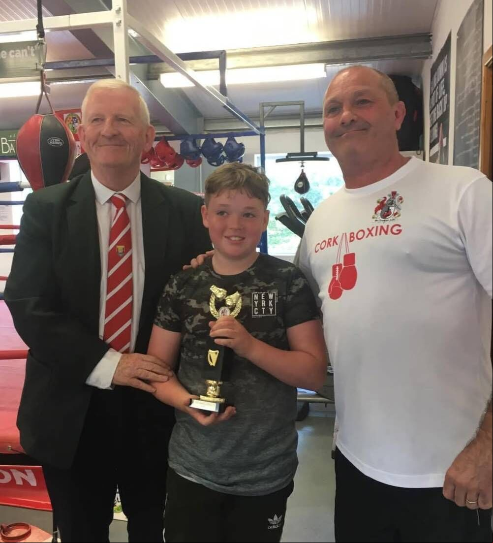 Cork Boxing County Board president Michael O'Brien with De Courey boxer Leon Healy and head coach Will Rossall.