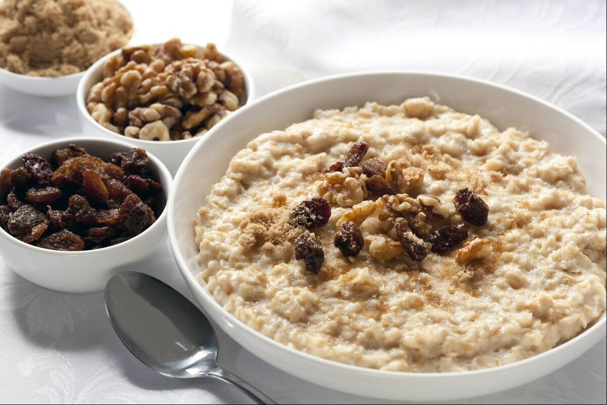 Oatmeal with raisins, walnuts, and brown sugar. Delicious traditional porridge. Oatmeal with raisins, walnuts, and brown sugar. Delicious traditional porridge.